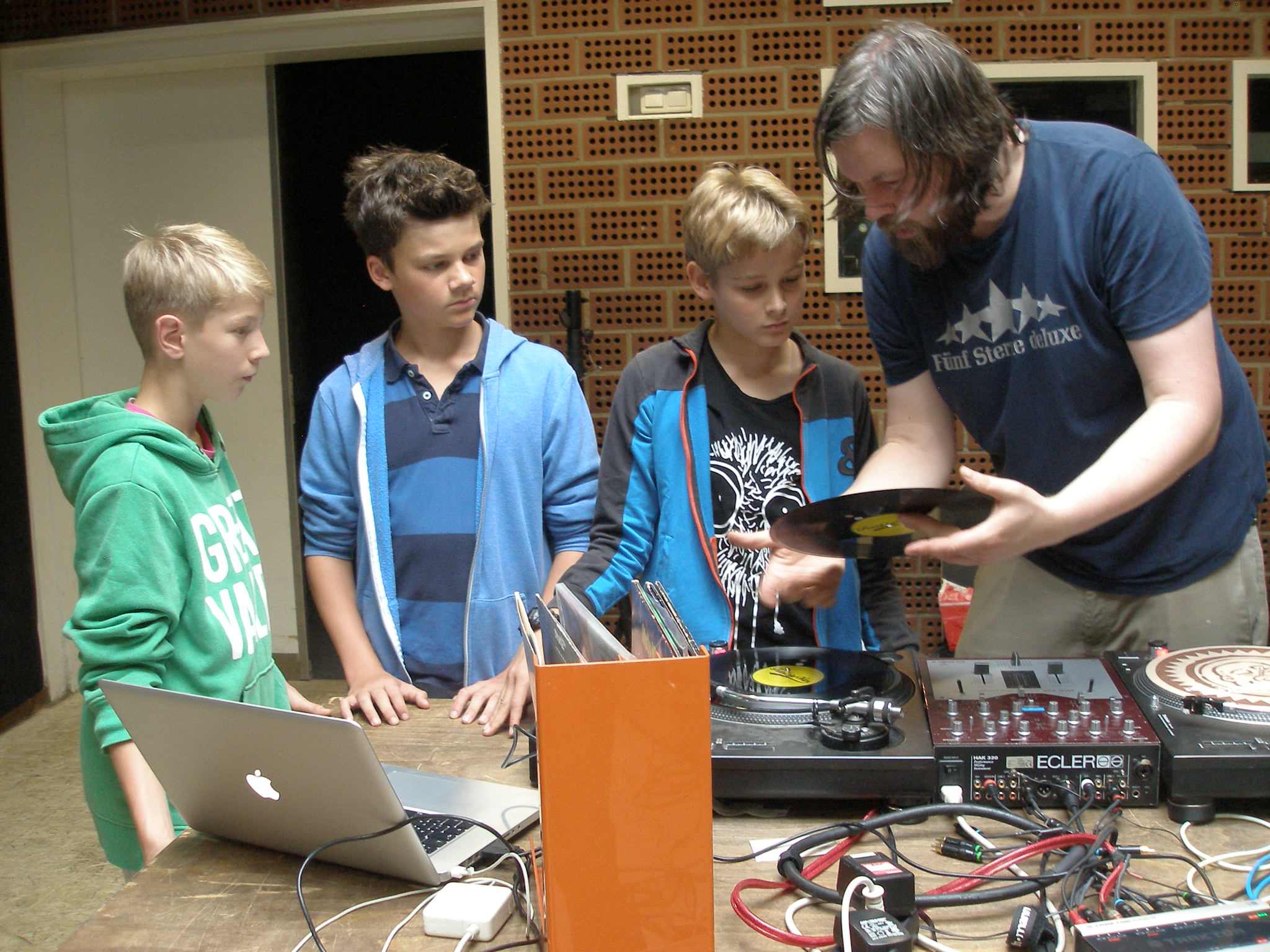 DJ AT zeigt den Teilnehmer den Umgang mit Vinyl-Platten. Foto: Bertels